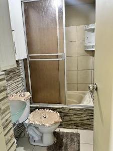a bathroom with a toilet and a sink and a tub at bonito departamento cerca al Aeropuerto Jorge Chávez in San Antonio