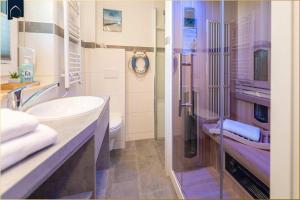 a bathroom with a sink and a toilet and a shower at Ferienhaus Glück unter Reet in Zirchow +27 photos