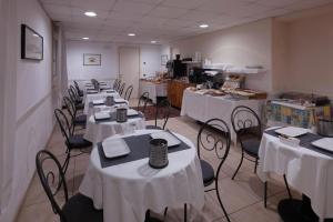 a row of tables and chairs with white table cloth at CityHotel Cristina Vicenza in Vicenza