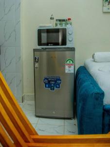a microwave on top of a refrigerator in a room at Lapis Studio with Netflix and WI-FI in Nanyuki