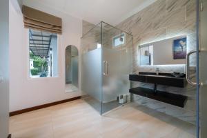 a bathroom with a glass shower and a sink at Phuket La Siesta Pool Villas & Pool Access Rooms in Nai Harn Beach