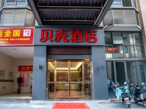 un bâtiment avec une enseigne sur la façade dans l'établissement Shell Hotel Hefei Feixi County Huamucheng, à Shangpai