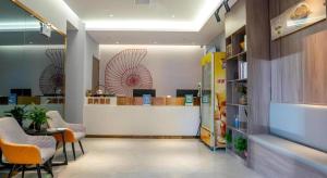 un hall d'entrée avec une salle d'attente avec des chaises et un comptoir dans l'établissement Shell Hotel Hefei Feixi County Huamucheng, à Shangpai