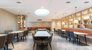 a restaurant with tables and chairs in a room at GreenTree Inn Jinan West Station Exhibition Center in Jinan
