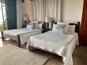 um quarto de hotel com duas camas e uma janela em Villa Del Mar 2 Spectacular ocean view! em Dominical mais 25 fotografias