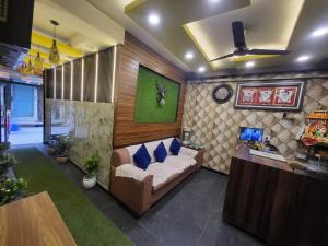 a living room with a couch with blue pillows at Hotel New Pratap in Haridwār
