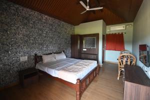 une chambre avec un lit et un ventilateur de plafond dans l'établissement Basilica Residency, à Māvalli 1 autre photo