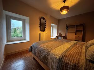 una camera da letto con un letto e una finestra di NESST - Gîte Horse & Dog Friendly Cottage a Saint-Setiers