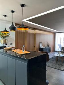 a room with a kitchen with a counter and chairs at Exclusive apartment a few steps from the FNSM in Aguascalientes