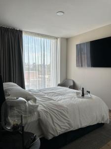 a bedroom with a large bed and a large window at Exclusive apartment a few steps from the FNSM in Aguascalientes