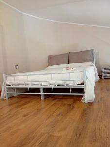 a large white bed in a room with a wooden floor at Sapori e Sapere di Troisi Margherita in Sicignano degli Alburni