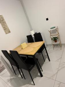 a wooden table with black chairs in a room at CasaKallisti in Levádeia