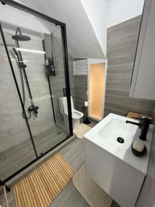 a bathroom with a white sink and a shower at Casa Kallisti in Livadeia +11 photos
