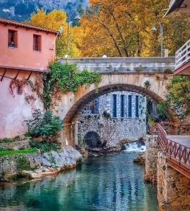 an old bridge over a river in a city at CasaKallisti in Levádeia +15 photos