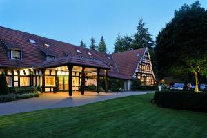 ein großes Haus mit einem großen Gameradach in der Unterkunft VILA VITA Burghotel Dinklage in Dinklage