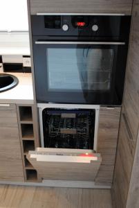 a kitchen with a microwave oven in a cabinet at Apartament 1Maja in Koszalin