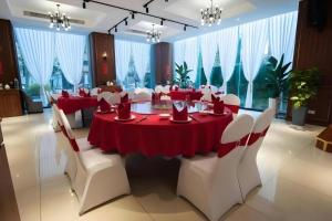 a dining room with a red table and white chairs at NanYing Hotel Shanghai in Shanghai
