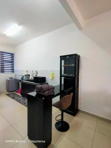 a kitchen with a counter and a chair in a room at NH Stay, Parit Buntar Perak in Parit Buntar