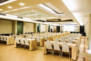 a room with rows of tables and white chairs at River Kwai Village Hotel in Ban Kaeng Raboet +227 photos
