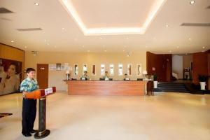 a young boy standing in a lobby with a sign at Sanya Luyi Sea View Hotel in Sanya