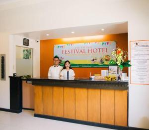 a man and woman standing at a restaurant counter at Ati-Atihan Festival Hotel in Kalibo