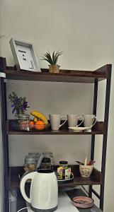a shelf with dishes and a microwave on it at At lilac, Jeffreys Bay, cottage for 2 in Jeffreys Bay