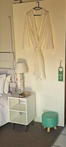a bedroom with a dresser and a robe hanging on a wall at At Lilac Cottage, Jeffreys Bay Cozy stay for 2 & Business traveling in Jeffreys Bay