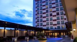 ケディリにあるGrand Surya Hotel Kediriの建物の前にテーブルと椅子が置かれたホテル