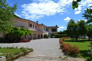 a driveway in front of a house with flowers at Agriturismo La Dolza in Follina