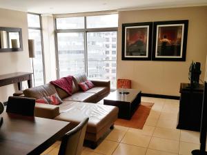 uma sala de estar com um sofá e uma mesa em Luxury Apartments at the Icon, Walking distance to CTICC in Cape Town em Cidade do Cabo