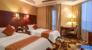 a hotel room with two beds and a desk at Ramada by Wyndham Wujiaochang Shanghai in Shanghai +78 photos