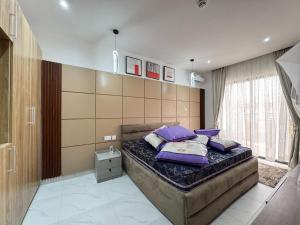 a bedroom with a large bed with purple pillows at Fafje Luxury in Mama