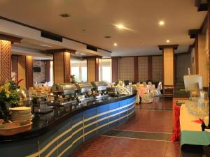 un restaurant avec une ligne de buffet avec des tables et des chaises dans l'établissement Thepnakorn Hotel, à Ban Khok Wat