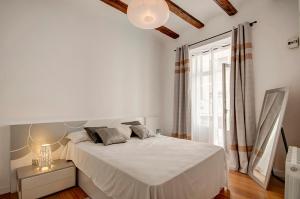 a white bedroom with a large bed and a window at Beds & Breaks Boyvin in Valencia