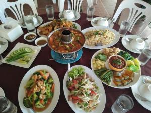 une table avec de nombreuses assiettes de nourriture dessus dans l'établissement Ban Naam Resort, à Ban San Wat Noi