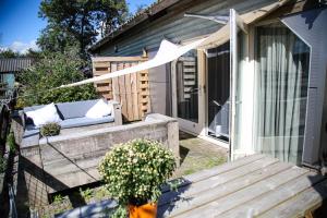 a porch of a house with a bench at Apartment De Stranding in Egmond aan den Hoef