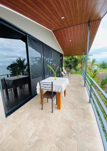 an outdoor patio with a white table and chairs at Villa Del Mar 3 Spectacular ocean view in Savegre