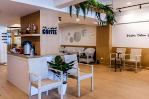 a coffee shop with white chairs and a counter at Magic House Hostel in Cha Am