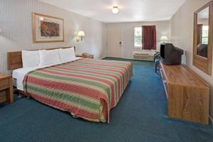 a hotel room with a bed and a flat screen tv at Knights Inn South Houston TX in Houston