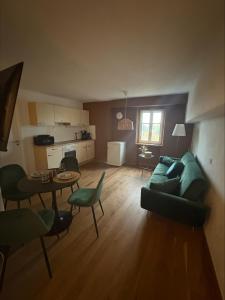 a living room with a green couch and a table at Schlossblick in Sulzbach-Rosenberg