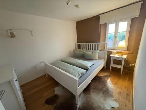 a white bed in a room with a window at Schlossblick in Sulzbach-Rosenberg