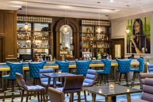 倫敦的住宿－肖爾迪奇庭院酒店，一间设有蓝色椅子的餐厅和一间酒吧