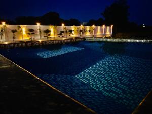 a swimming pool lit up at night with lights at Sandhika Retreat in Varanasi