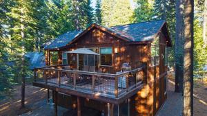 eine Hütte im Wald mit einer großen Terrasse in der Unterkunft Cozy Tahoe Retreat w Hot Tub Movie Room Forest Views 10th ave 2 by AvantStay in Tahoma