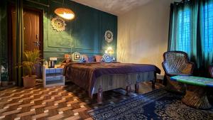 カナタルにあるBagheecha Homestayのベッドと緑の壁のある寝室