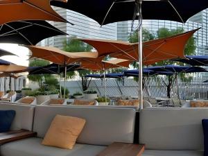 a row of tables with umbrellas in a restaurant at Luxury Suites International by Vdara in Las Vegas