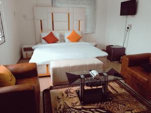 カラバルにあるLincolyn royale hotel calabarのベッドとコーヒーテーブルが備わるホテルルームです。