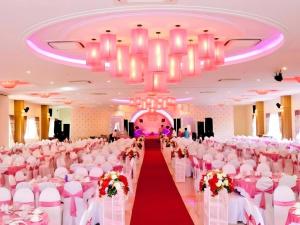 a banquet hall with white chairs and a red carpet at Hoa Binh - Rach Gia Resort in Rach Gia +91 photos
