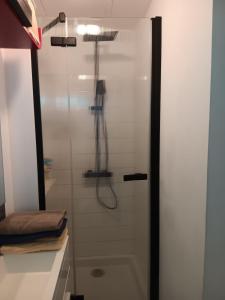 una ducha con puerta de cristal en un baño en Un nid douillet sous les toits, en Cancale 14 fotos más