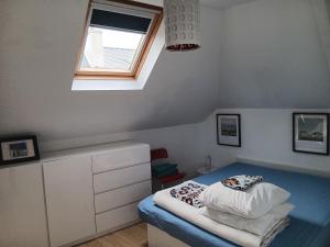 Un dormitorio pequeño con una cama y una ventana. en Un nid douillet sous les toits, en Cancale